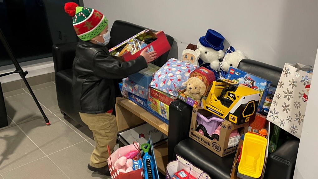Henry helps carry and organize new, unwrapped toy donations into the CTV lobby.
