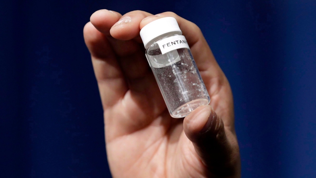 FILE - In this June 6, 2017 file photo, a reporter holds up an example of the amount of fentanyl that can be deadly after a news conference about deaths from fentanyl exposure, at The Drug Enforcement Administration headquarters in Arlington, Va.  (AP Photo/Jacquelyn Martin, File)