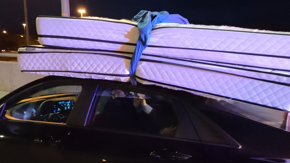 holding mattress on top of car