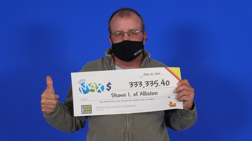 Shawn Irvin, a potato farmer in Alliston, Ont. hold his big cheque from OLG after winning in the June 11, 2021, draw. (OLG)