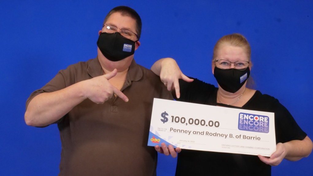 Rodney and Penney Bailey, of Barrie, Ont., hold their big cheque after winning $100,000 with their Encore numbers in the Lotto Max Dec. 24, 2021, draw. (OLG/Jan. 17, 2022)