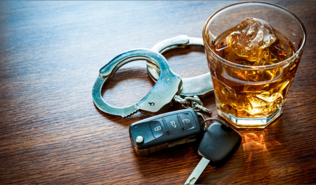 Police handcuffs, vehicle keys and an alcoholic beverage. (File photo)