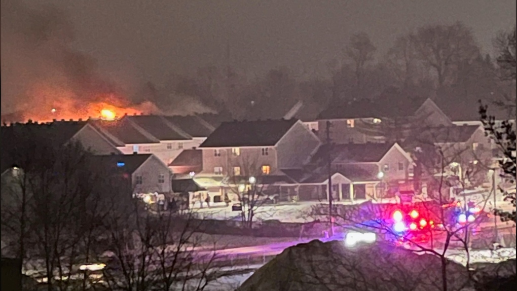 Flames are seen shooting from a home in a complex in Midland, Ont., on Sat., March 18, 2023. (Photo Courtesy: Patty Black)