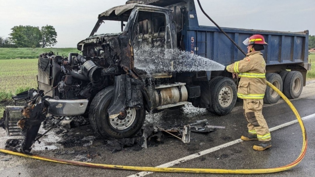 A firefighter works to extinguish hot spots after fire tore through a dump truck in Caledon, Ont., on Thurs., June 8, 2023. (Source: OPP/Twitter)